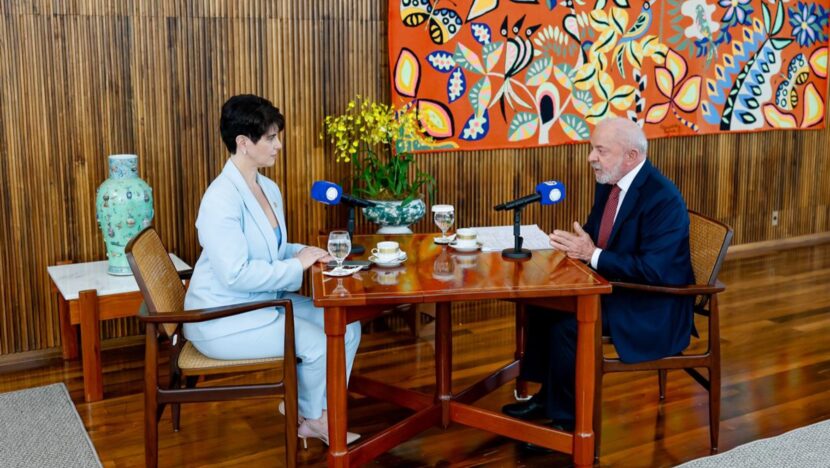 Presidente Lula, de terno escuro, sentado à mesa diante da jornalista Mariana Godoy durante entrevista à Record