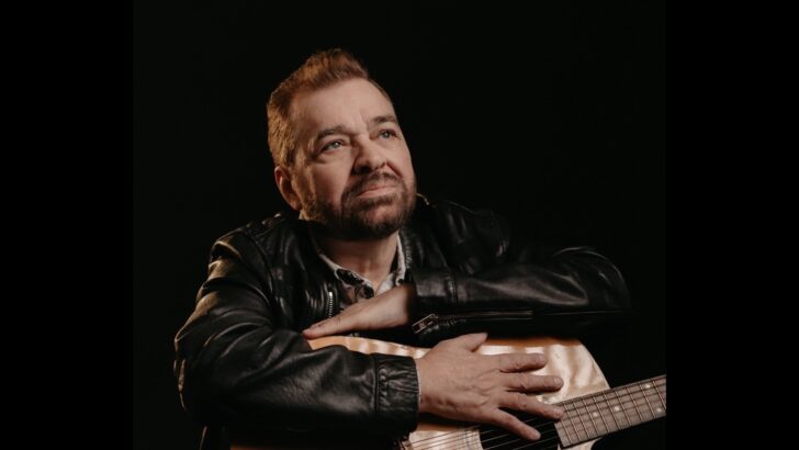 O cantor e compositor Peninha posa com um violão