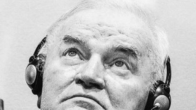 Ratko Mladic, de fones de tradução, olha para cima durante audiência no tribunal de Haia, em foto em preto e branco