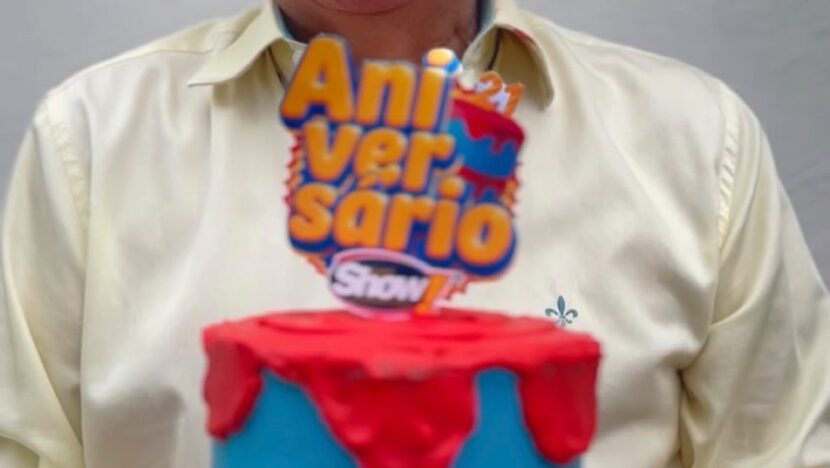 Homem segura bolo de aniversário de 21 anos do Super Show