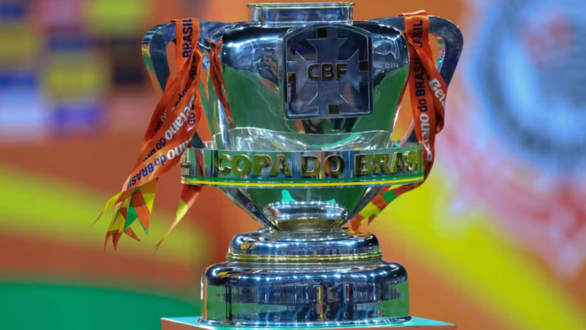 Troféu prateado da Copa do Brasil com fitas alaranjadas preso às alças e o símbolo da CBF na parte frontal