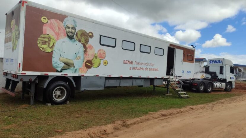 Unidade móvel de capacitação do Senai estacionada em área externa da Expo Macaíba sob céu parcialmente nublado