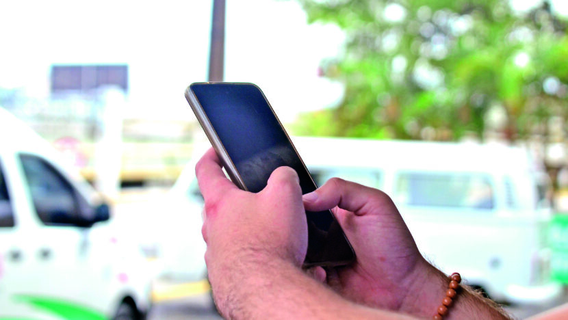 Pessoa segura celular com aplicativo aberto