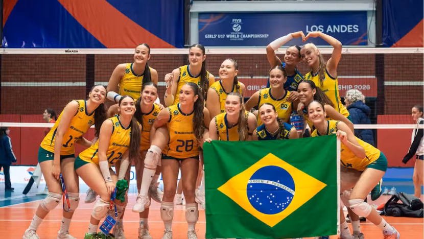 Jogadoras da seleção brasileira feminina Sub-17 de vôlei posam em quadra com a bandeira do Brasil