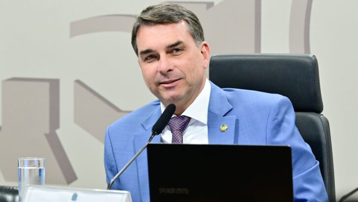 Senador Flávio Bolsonaro de paletó azul durante reunião