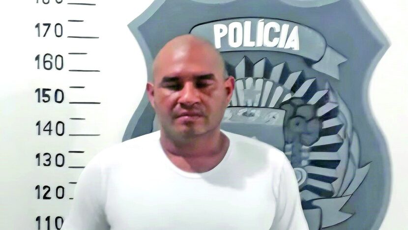 Anderson Stallone Flores dos Santos diante de painel policial