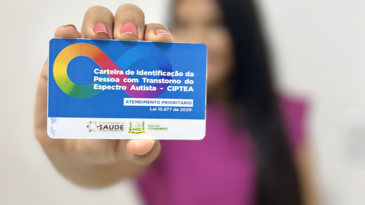Pessoa segura uma Carteira de Identificação da Pessoa com Transtorno do Espectro Autista, a CIPTEA