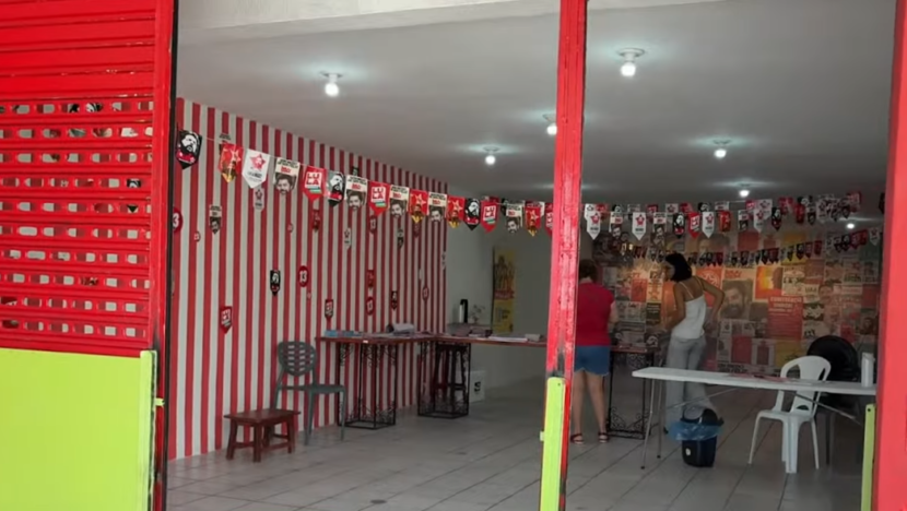Interior de comitê de campanha com material eleitoral de Lula após registro de arrombamento