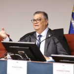 Flávio Dino, de toga e óculos, sentado à bancada durante sessão