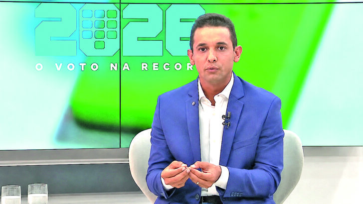 Allyson Bezerra durante entrevista, usando paletó e camisa branca