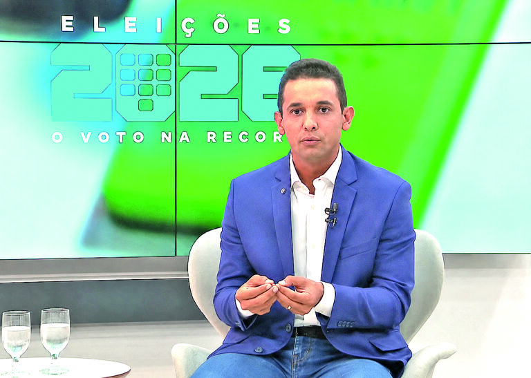 Allyson Bezerra durante entrevista, usando paletó e camisa branca