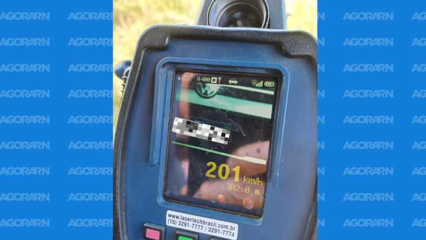 Tela de radar portátil mostra a frente de um Volkswagen com a placa ocultada e o registro de velocidade de 201 km/h.