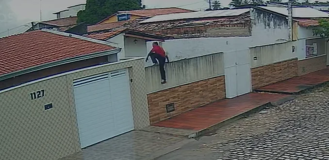 Imagem de câmera de segurança mostra homem sobre o muro de uma residência