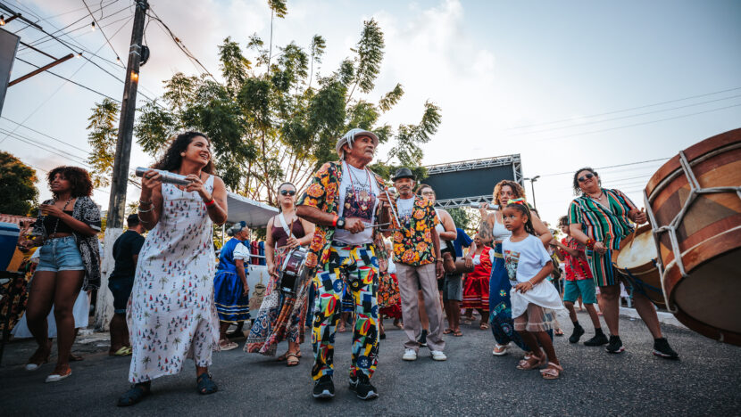 Participantes do Ecopraça caminham em cortejo com instrumentos de percussão
