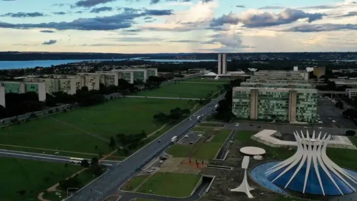 Vista aérea da Esplanada dos Ministérios, em Brasília, com prédios públicos e a Catedral Metropolitana em primeiro plano
