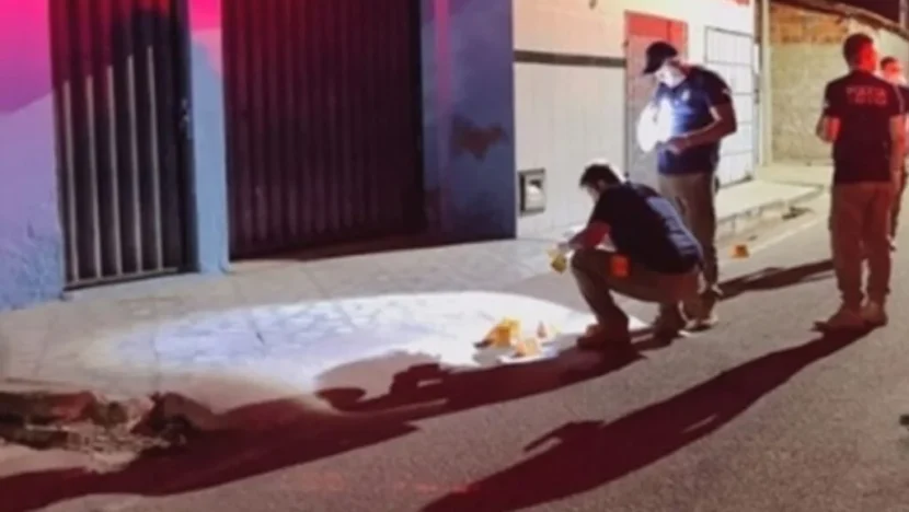 Profissionais realizam perícia em uma rua durante a noite, com marcadores posicionados no local da ocorrência