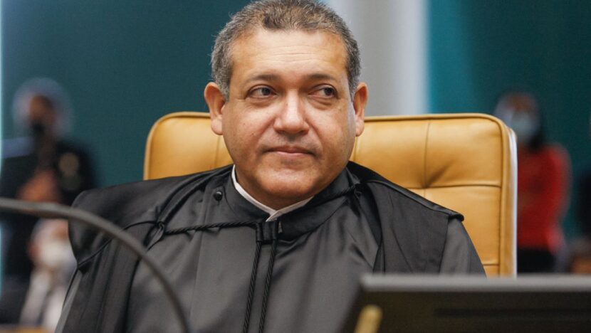 Homem usando toga preta sentado durante sessão em tribunal