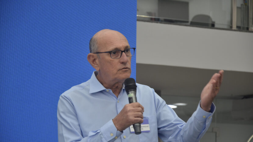 Roberto Serquiz fala ao microfone e gesticula durante encontro
