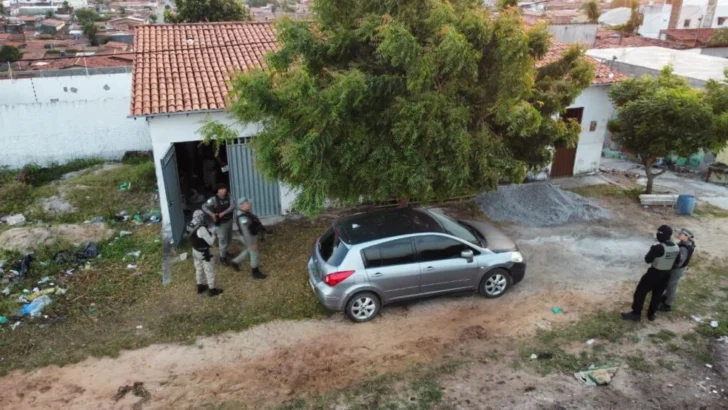 Agentes de segurança durante operação em área residencial, com veículo estacionado diante de um imóvel