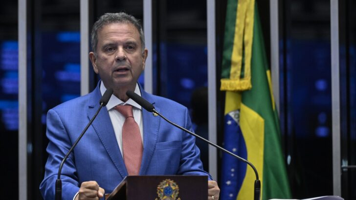Senador Rogério Marinho fala ao microfone no púlpito do Senado, com bandeiras ao fundo