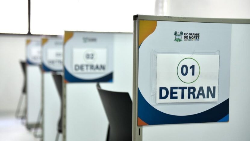 Guichês de atendimento do Detran-RN numerados, com divisórias e cadeiras vazias