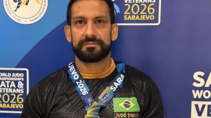 Judoca de quimono azul diante de painel com a inscrição World Judo Championships Veterans 2026 Sarajevo