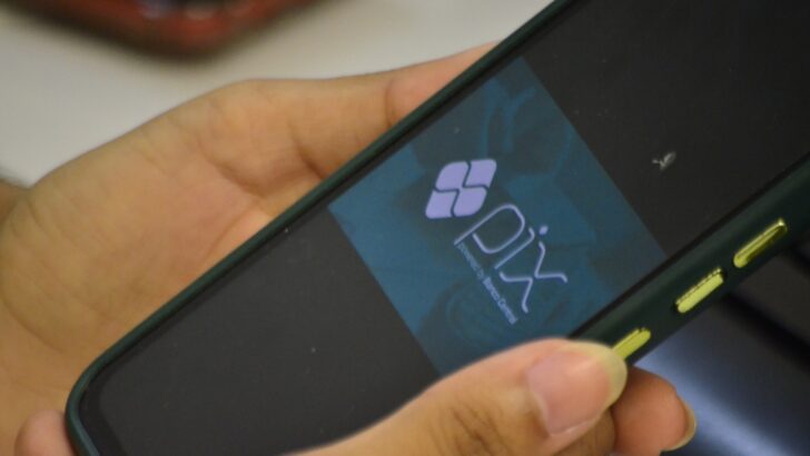 Mão segura um celular com o logotipo do Pix aberto na tela
