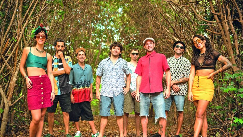 Sete integrantes da banda Skabulosa posam em pé, lado a lado, num trecho de mata, em foto de divulgação