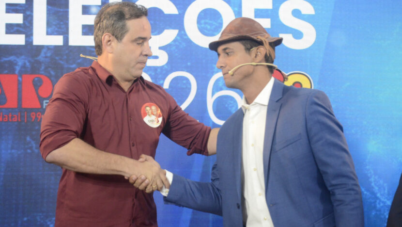 Cadu de Lula e Allyson Bezerra apertam as mãos diante do painel do debate Eleições 2026