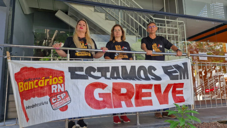 Bancários seguram faixa "Estamos em greve" do Sindicato dos Bancários do RN