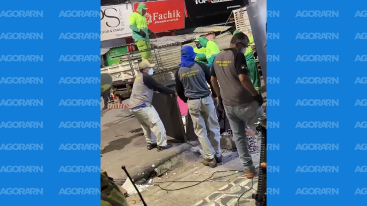 Trabalhadores e agentes de fiscalização durante retirada de estrutura comercial em via pública