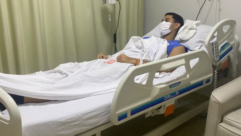 Jovem usando máscara de proteção deitado em leito hospitalar durante tratamento
