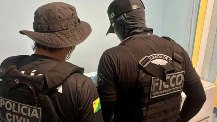 Dois agentes das forças de segurança vistos de costas durante operação policial