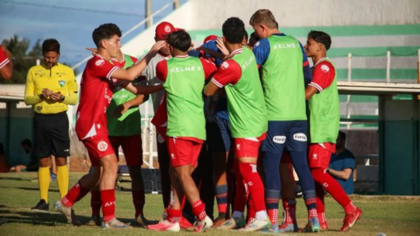 Jogadores do América reunidos em comemoração à beira do campo durante partida de futebol