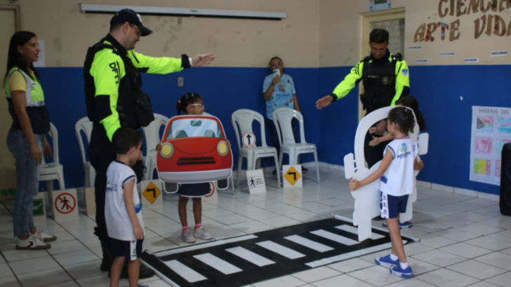 Crianças participam de atividade educativa com agentes de trânsito e faixa de pedestres simulada em sala