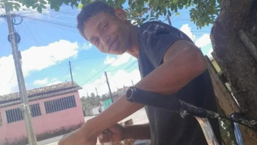 Jovem sentado ao lado de uma árvore em área externa