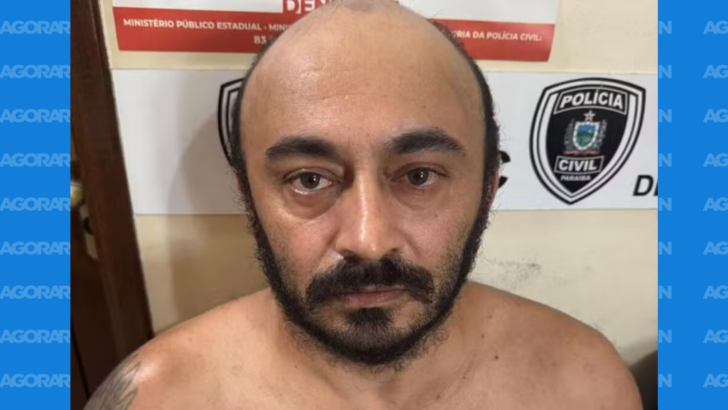 Homem aparece diante de painel com identificação visual da Polícia Civil da Paraíba