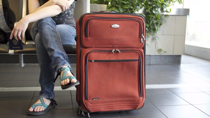 Passageira ao lado de mala em aeroporto
