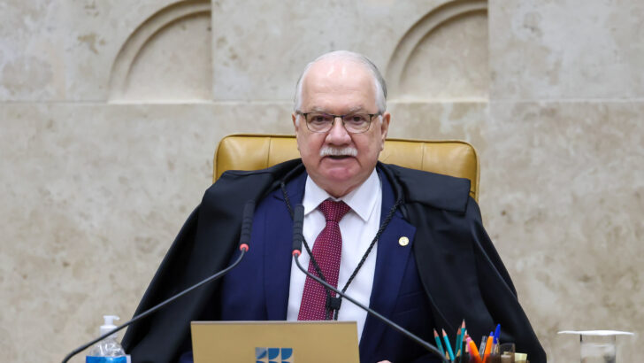 Ministro Edson Fachin, de toga, fala ao microfone na presidência do plenário do STF