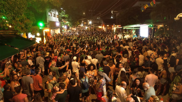 Público lotando a rua principal de Pipa durante evento noturno