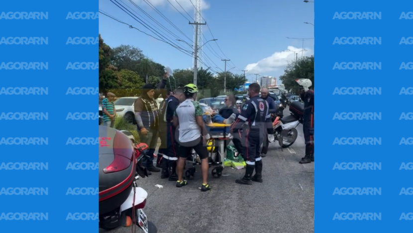 Socorristas do Samu atendem mulher deitada em uma maca na BR-101, ao lado de motocicletas de resgate e pessoas que acompanham o atendimento.