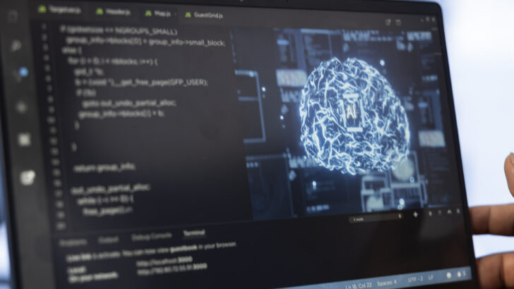 Tela de laptop exibindo código de programação e uma representação visual de inteligência artificial