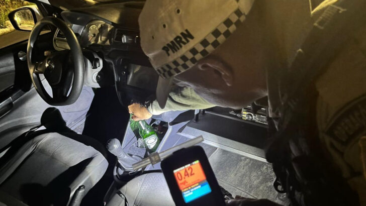 Agente de trânsito aplicando teste de bafômetro em motorista durante blitz