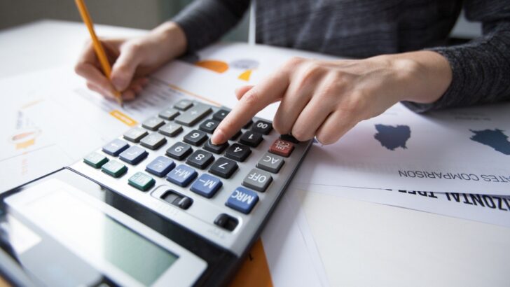Pessoa faz cálculos com calculadora