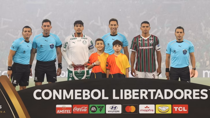 Jogadores de Palmeiras e Fluminense, árbitros e duas crianças posam atrás de placa da Libertadores no Maracanã