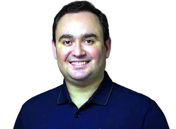 Gustavo Fernandes, de camisa polo azul-escura, posa sorrindo