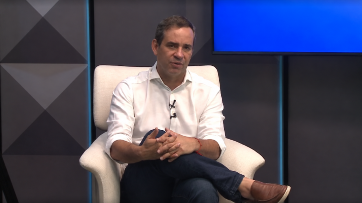 Cadu Xavier sentado durante entrevista na televisão