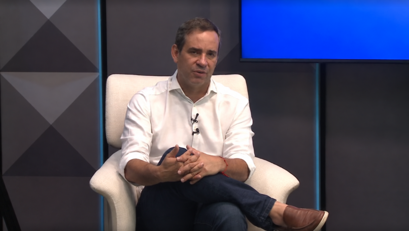Cadu Xavier sentado durante entrevista na televisão