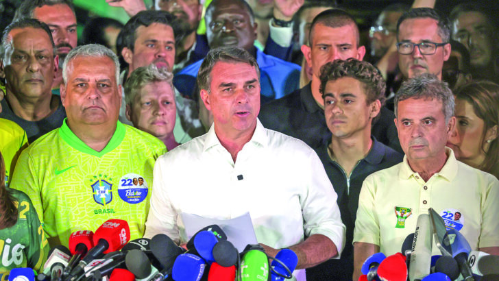 Flávio Bolsonaro fala com jornalistas, acompanhado por aliados