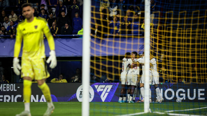 Jogadores do Vasco se abraçam em comemoração atrás da rede, com o goleiro do Boca Juniors em primeiro plano